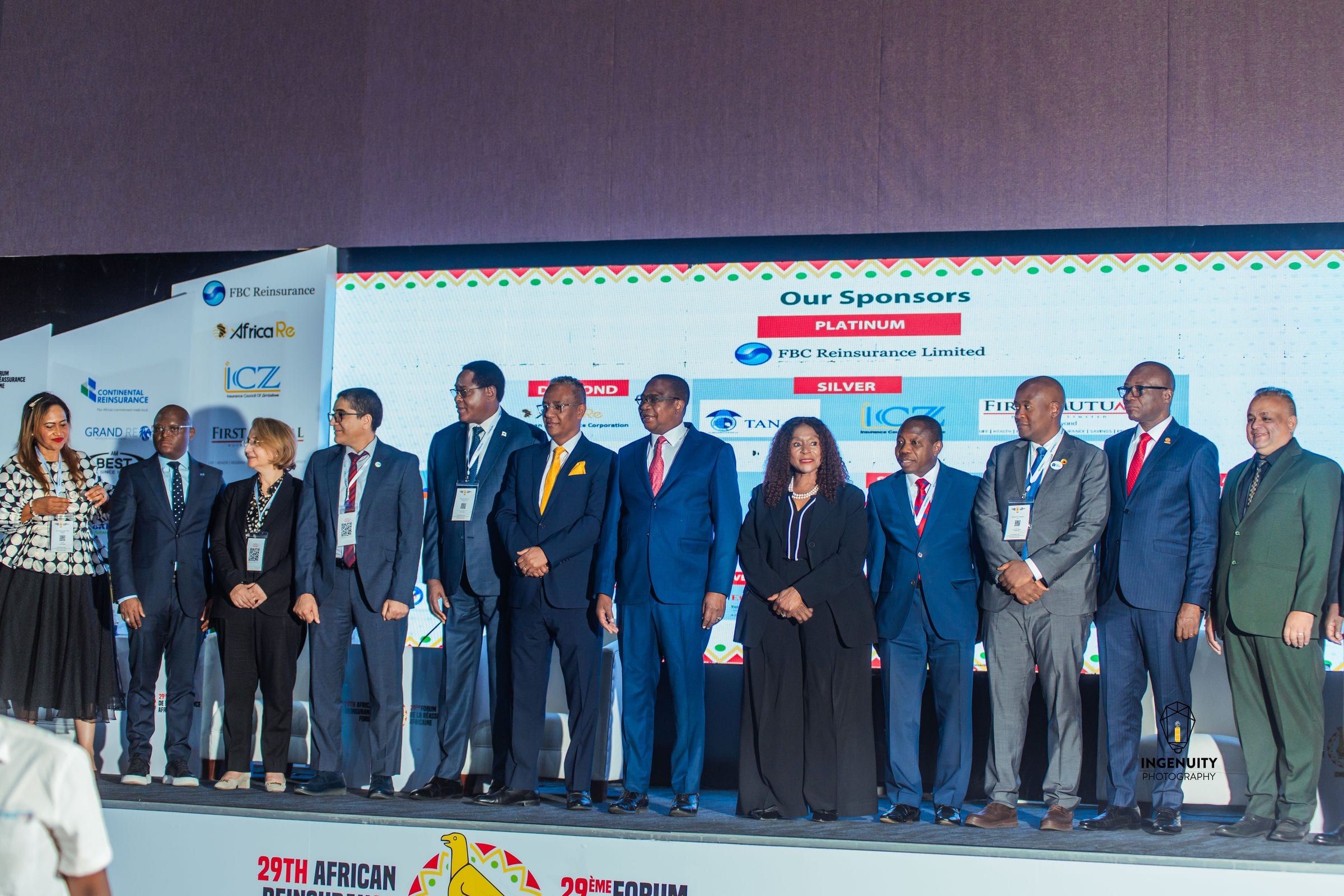 Delegates on stage in front of a branded sponsor wall