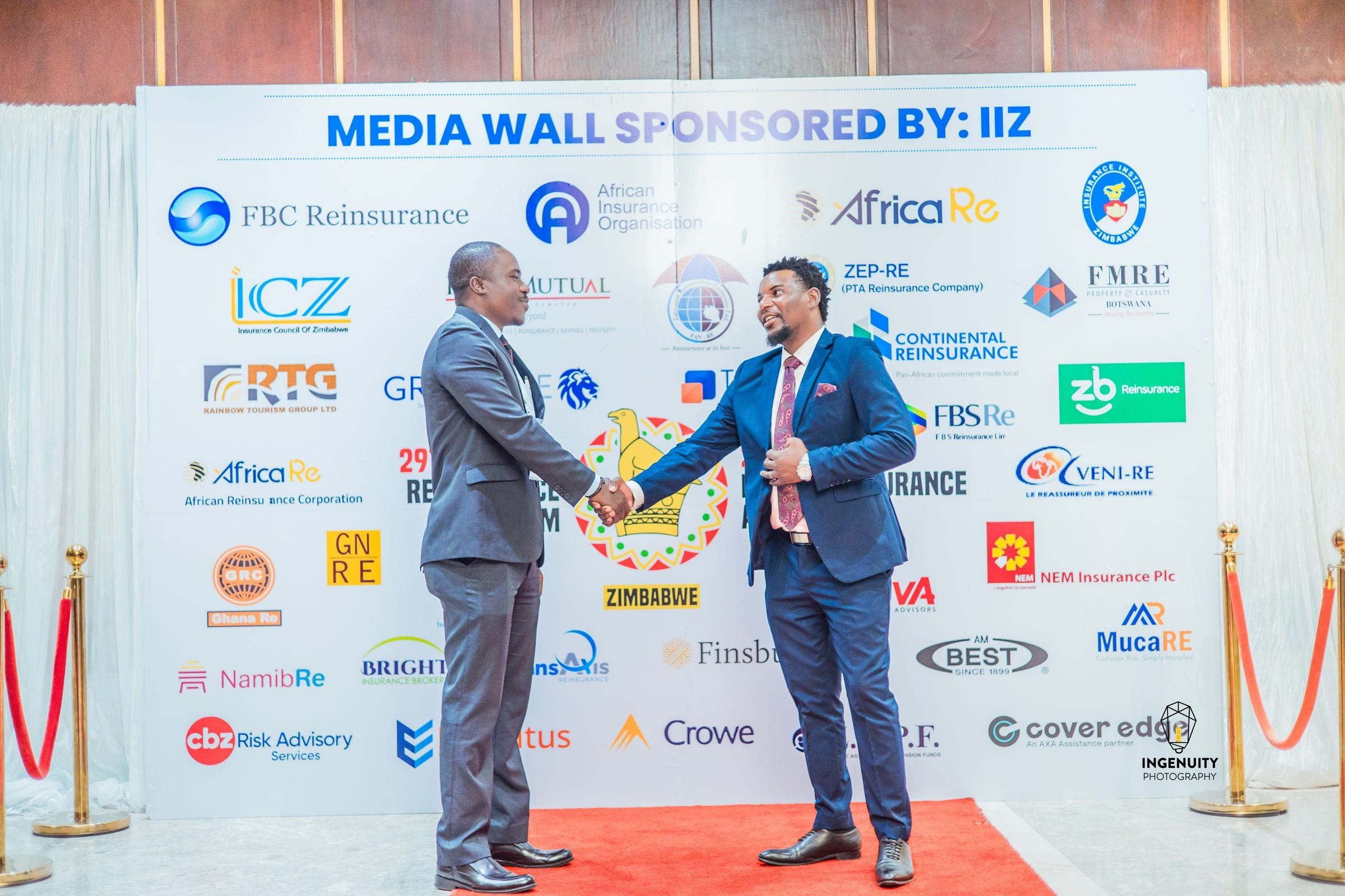 A handshake in front of a sponsored media wall