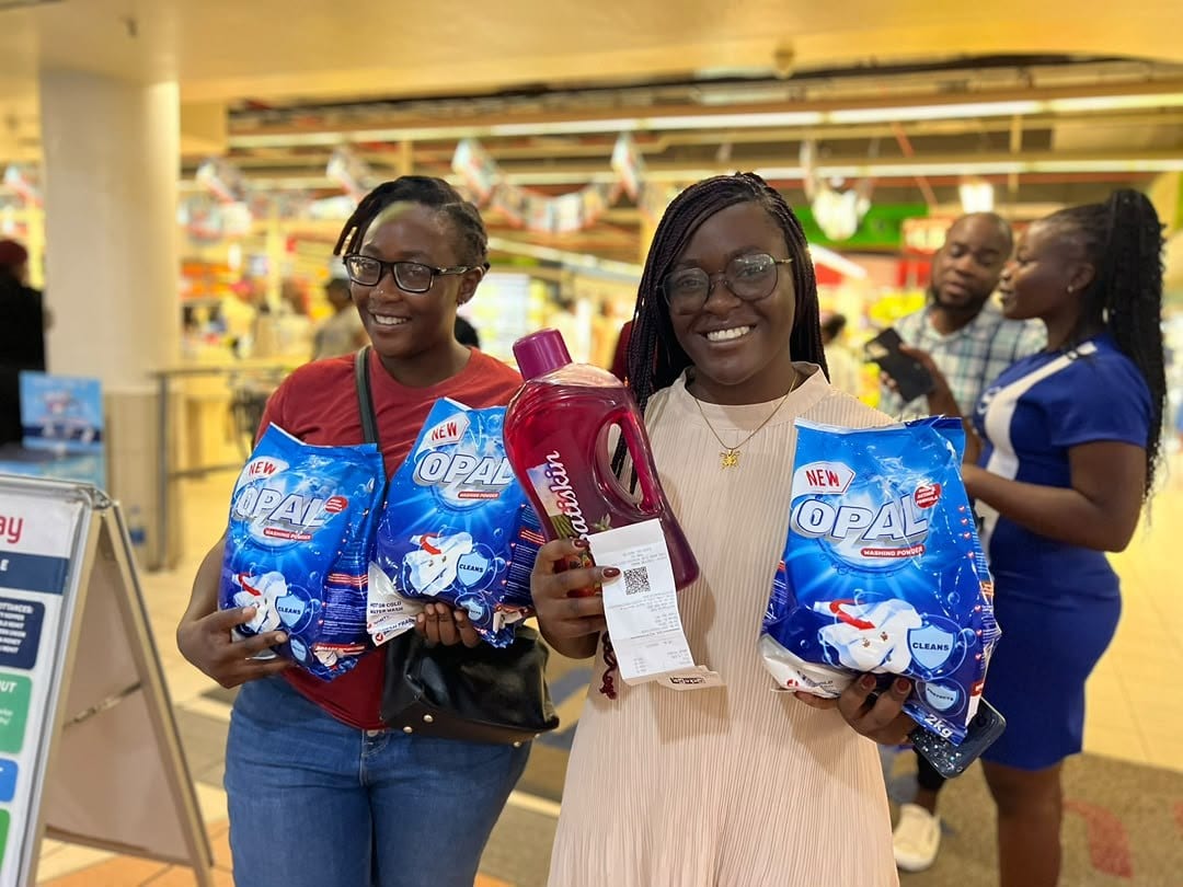 Two shoppers in store holding Opal packs and a promotion slip
